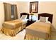 Bedroom featuring two twin beds, tile floors and matching artwork at 3050 Pirates Retreat Ct # 103, Kissimmee, FL 34747