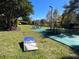 A lovely outdoor community area with picnic tables, grill, and a cornhole game on lush green grass at 3050 Pirates Retreat Ct # 103, Kissimmee, FL 34747