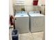 Bright laundry room with full-size washer, dryer, and shelving at 3050 Pirates Retreat Ct # 103, Kissimmee, FL 34747