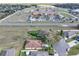 An aerial view of a home with a brown roof, surrounded by a green lawn and nearby houses at 32107 Spring Meadow Ct., Sorrento, FL 32776