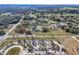 An aerial view of a suburban home surrounded by trees, and close to a parking lot at 32107 Spring Meadow Ct., Sorrento, FL 32776