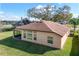 Back exterior of home with screen patio, large yard, and neutral color palette at 32107 Spring Meadow Ct., Sorrento, FL 32776