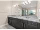 Bathroom with double sink vanity, dark cabinets, granite countertop, tile flooring, and a view of the tub and shower at 32107 Spring Meadow Ct., Sorrento, FL 32776