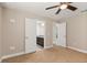 Neutral bedroom with carpet, ceiling fan, and view into the ensuite bathroom at 32107 Spring Meadow Ct., Sorrento, FL 32776