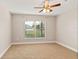 Bedroom with neutral walls, carpet, ceiling fan, and view from the window at 32107 Spring Meadow Ct., Sorrento, FL 32776