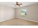 Cozy bedroom with neutral carpet, ceiling fan, and a bright window offering pleasant natural light at 32107 Spring Meadow Ct., Sorrento, FL 32776