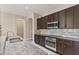 Modern kitchen with granite countertops, stainless steel appliances, and dark wood cabinetry at 32107 Spring Meadow Ct., Sorrento, FL 32776