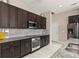 Stylish kitchen with stainless steel appliances, dark cabinetry, and elegant granite countertops at 32107 Spring Meadow Ct., Sorrento, FL 32776