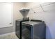 Modern laundry room featuring a washer, dryer, and wire shelving unit at 32107 Spring Meadow Ct., Sorrento, FL 32776