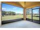 Screened patio showcasing an outdoor view of the lush green backyard with a clear blue sky at 32107 Spring Meadow Ct., Sorrento, FL 32776