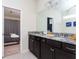 Modern bathroom featuring granite countertops, dual sinks, and a view into the bedroom at 3312 Lilac Wa, Davenport, FL 33897