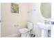 Clean bathroom featuring a toilet, pedestal sink, and decorative artwork at 3312 Lilac Wa, Davenport, FL 33897