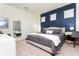 Stylish bedroom featuring a navy accent wall, neutral bedding, and modern decor at 3312 Lilac Wa, Davenport, FL 33897