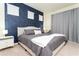 Bright bedroom with a navy accent wall, plush bedding, and elegant bedside tables at 3312 Lilac Wa, Davenport, FL 33897