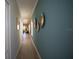 Hallway featuring tile floor and blue accent wall with modern, circular artwork at 3927 Sagefield Dr, Harmony, FL 34773