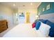 Bright main bedroom featuring blue accent wall, dresser, and doorway to ensuite bathroom at 3927 Sagefield Dr, Harmony, FL 34773