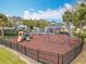 A fenced playground area with a variety of play structures and swings, surrounded by greenery at 4020 Shawn Cir, Orlando, FL 32826