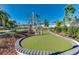 Outdoor mini golf course with a green putting surface surrounded by lush landscaping and trees at 4058 Lana Avenue, Davenport, FL 33897