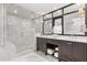 A luxurious bathroom featuring a glass shower, double vanity sinks, dark wood cabinets and white marble at 470 Manor Rd, Maitland, FL 32751