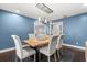 Stylish dining room featuring a wooden table, six chairs, modern lighting, and beautiful blue walls at 470 Manor Rd, Maitland, FL 32751