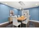 Stylish dining room featuring a wooden table, six chairs, modern lighting, and beautiful blue walls at 470 Manor Rd, Maitland, FL 32751