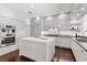 Modern white kitchen with stainless appliances, an island with seating, and plenty of cabinet space at 470 Manor Rd, Maitland, FL 32751