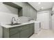 A laundry room with green cabinets, stainless sink, a washing machine and dryer, and tile floors at 470 Manor Rd, Maitland, FL 32751