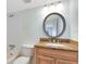 Bathroom with granite countertop vanity, round mirror, and combination shower and tub at 4705 S Texas Ave # 4705D, Orlando, FL 32839