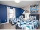 Bright bedroom featuring two twin beds with playful blue patterned bedding and artwork at 4844 Romeo Cir, Kissimmee, FL 34746