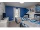 Bright bedroom showcasing twin beds with blue bedding, a dresser with a TV, and Disney & SeaWorld decor at 4844 Romeo Cir, Kissimmee, FL 34746