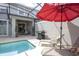 Swimming pool with patio area featuring lounge chairs, a grill, and an umbrella for shade at 4844 Romeo Cir, Kissimmee, FL 34746