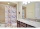 Bathroom featuring a shower-tub combo, granite countertop vanity, and decorative mirror at 5023 Southlawn Ave, Orlando, FL 32811