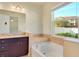 A full tub and granite vanity in the main bathroom at 5023 Southlawn Ave, Orlando, FL 32811