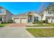 Charming one-story home featuring a three-car garage, stone accents, and a brick-paved driveway at 5023 Southlawn Ave, Orlando, FL 32811