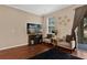 Cozy living room with wood floors, a large TV, and sliding glass doors to the outdoor patio at 5150 Fiorella Ln, Sanford, FL 32771