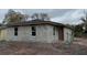 View of an unfinished block home with a new roof and modern windows ready for customization at 5238 2Nd St, Orlando, FL 32810