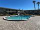 Community pool surrounded by a brick deck and palm trees at 5505 Hernandes Dr # Ge, Orlando, FL 32808