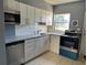 Bright kitchen with white cabinets, stainless steel appliances, and a window at 5505 Hernandes Dr # 125, Orlando, FL 32808