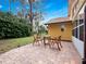 Brick patio with a table and chair set, surrounded by lush greenery and mature trees at 629 Nighthawk Cir, Winter Springs, FL 32708