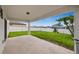 Covered patio overlooking a spacious backyard with a white privacy fence and a young papaya tree at 630 Citrus Isle Blvd, Davenport, FL 33837