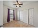 Bedroom with tile flooring, a ceiling fan, and a sliding door closet with paint color matching curtains at 630 Citrus Isle Blvd, Davenport, FL 33837