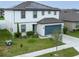 Two-story home with a well-maintained lawn, two car garage, and solar panels on the roof at 630 Citrus Isle Blvd, Davenport, FL 33837