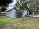 Rear exterior view showcases backyard with a shed, mature trees, and screened lanai at 636 Bohannon Blvd, Orlando, FL 32824