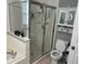 Updated bathroom with a glass enclosed shower, toilet, and a vanity with decorative shelving at 636 Bohannon Blvd, Orlando, FL 32824