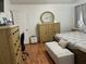 Bedroom with wood-look flooring, light colored furniture, and a comfortable bench in front of the bed at 636 Bohannon Blvd, Orlando, FL 32824