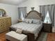 A cozy bedroom with a large, tufted headboard bed, soft gray bedding, and matching bedside tables at 636 Bohannon Blvd, Orlando, FL 32824