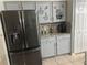 Updated kitchen features stainless steel refrigerator, granite countertops, and gray cabinetry at 636 Bohannon Blvd, Orlando, FL 32824