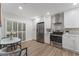 Well-lit eat-in kitchen with stainless steel appliances, stylish white cabinets, and wood flooring at 1055 Kensington Park Dr # 111, Altamonte Springs, FL 32714