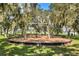 Community playground with swings and mulch ground cover, nestled amongst mature trees at 11178 Longleaf Woods Dr, Orlando, FL 32832