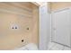 Laundry room with white tile, wire racks and separate access door to hallway at 11223 Huxley Ave, Orlando, FL 32837